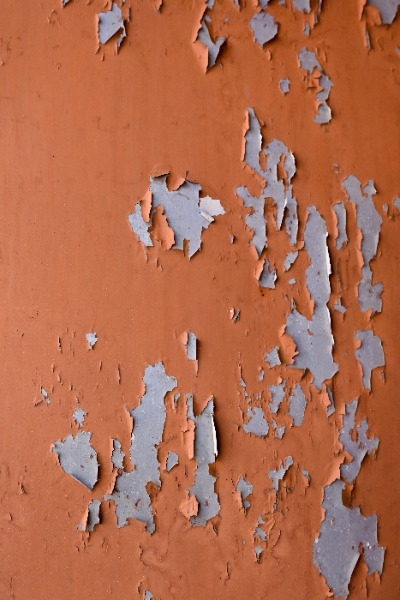 Rust colored paint chipping on a wall
